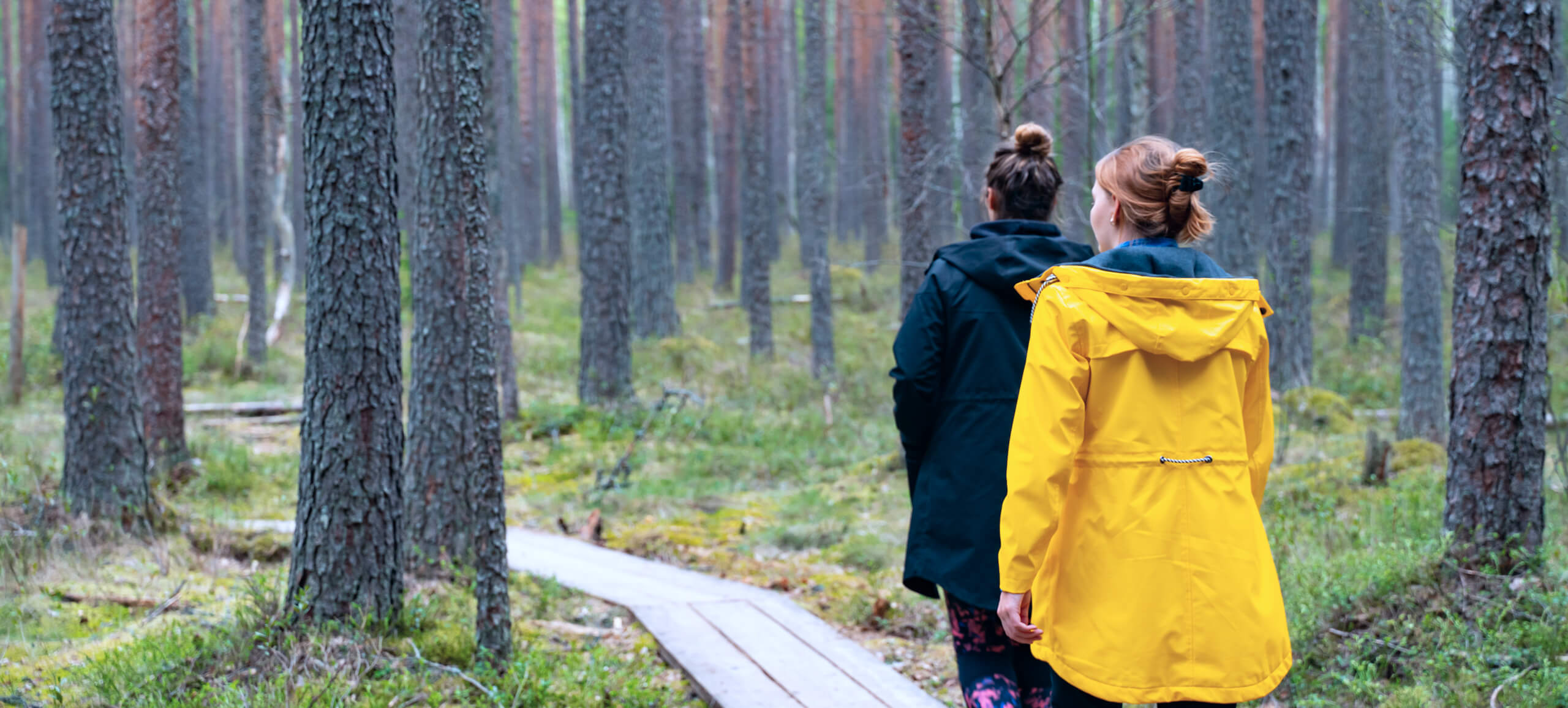 Två personer promenerar i en skog – frisk luft i naturen med astma.